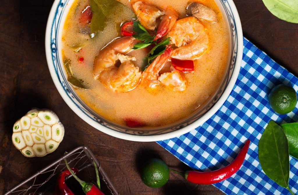 shrimp-soup-in-white-ceramic-bowl-with-chili-on-brown-wooden-1437590